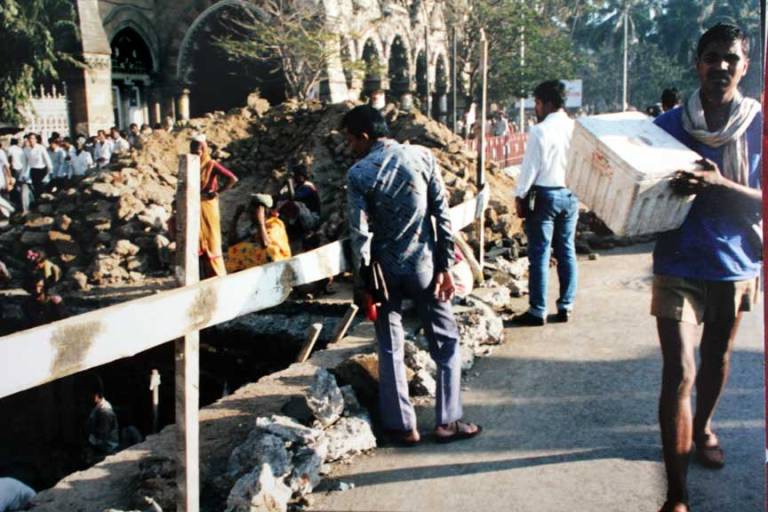 Women carrying dirt out  of a large hole, Mumbai